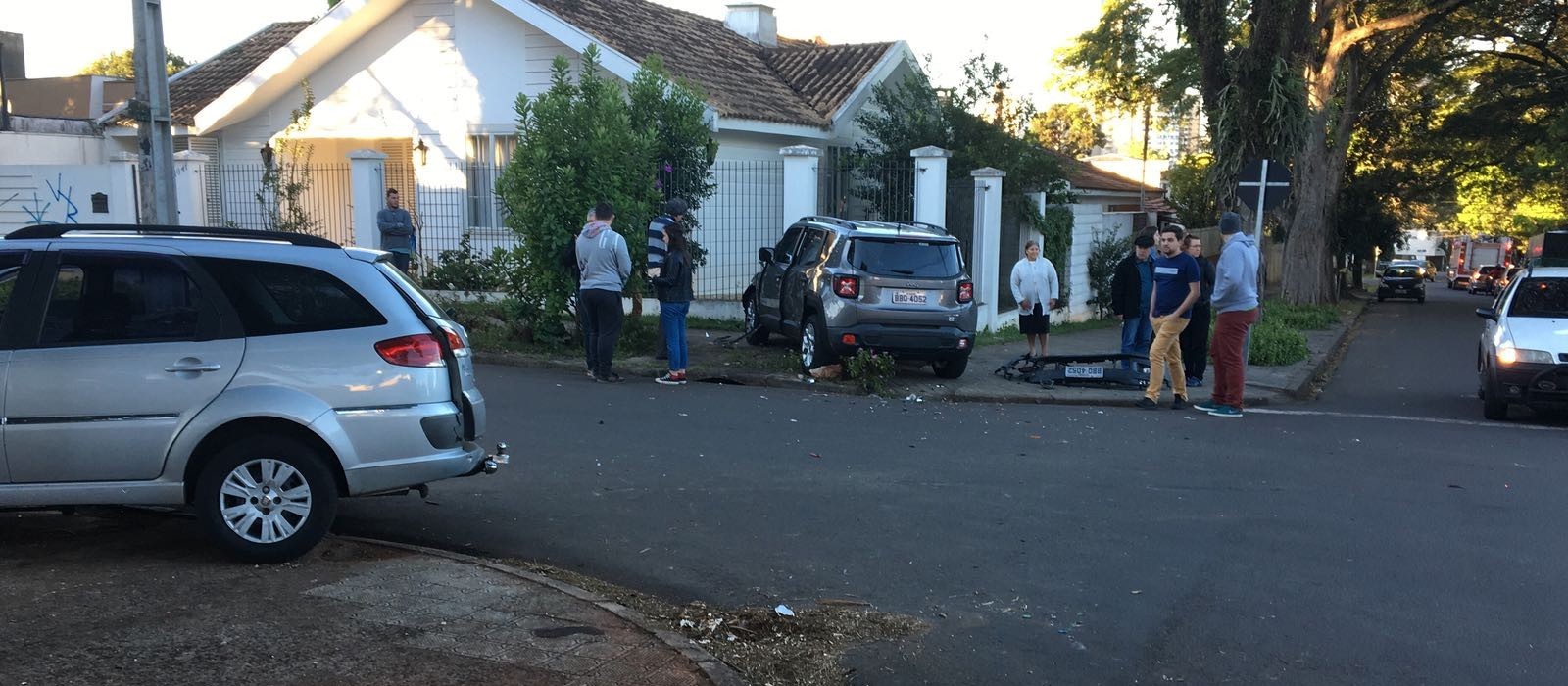 Carros batem em cruzamento e um deles quase invade uma casa