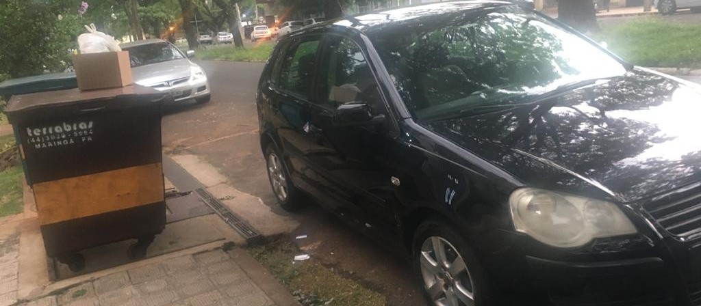 Carro estacionado em frente ao contêiner de lixo, impedindo a coleta