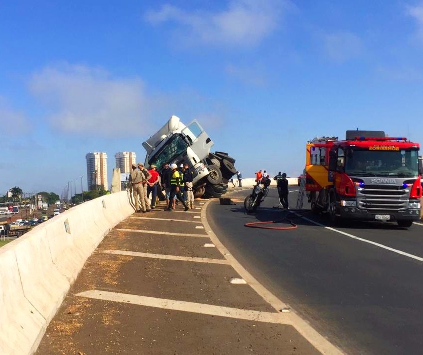 Carreta tomba sobre mureta, por pouco não cai debaixo de viaduto 