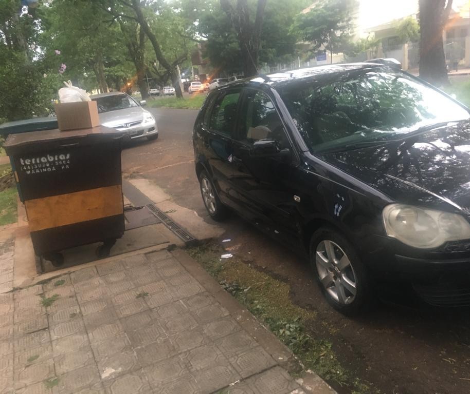 Carro estacionado em frente ao contêiner de lixo, impedindo a coleta